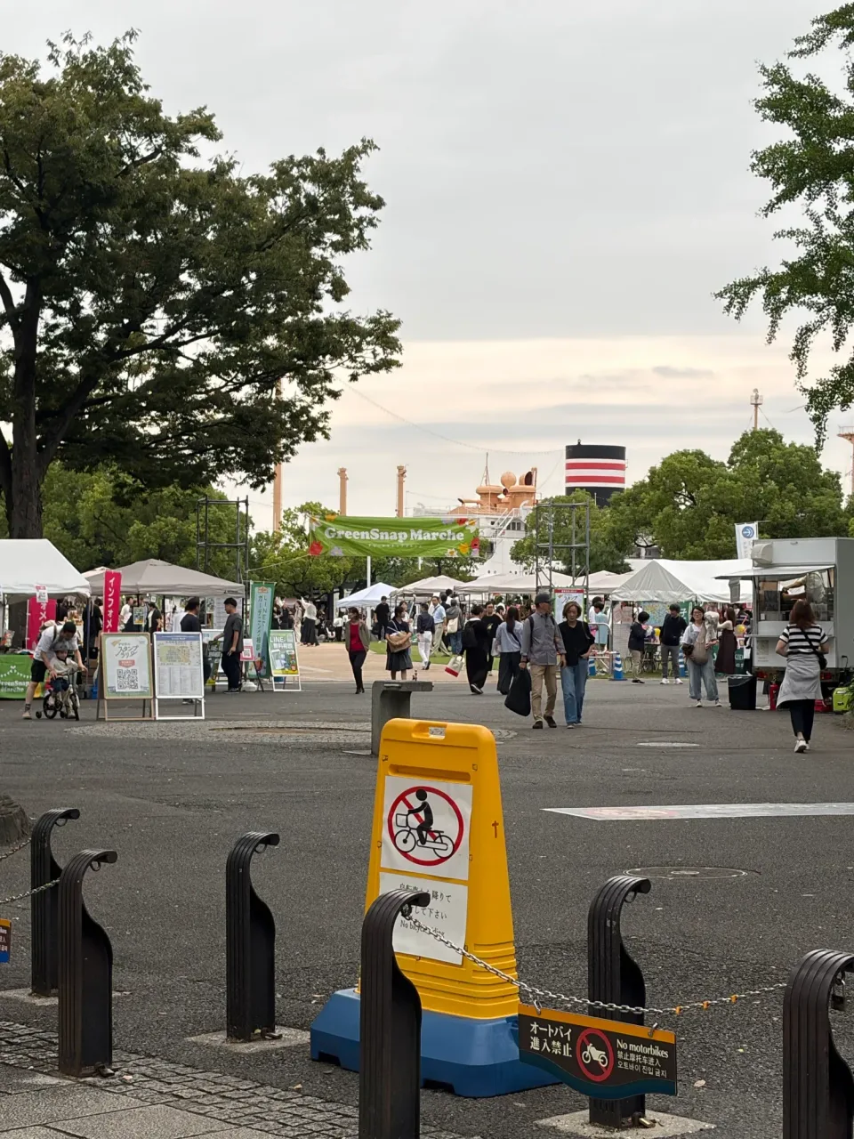 山下公園のおまつり広場にGreenSnap Marcheの横断幕と白いテントが並び、奥に氷川丸が見える
