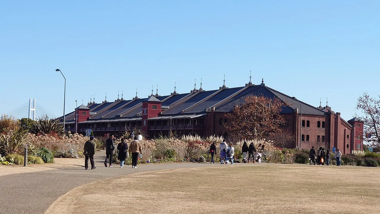 Venue reference photographed in January 2025, showing a Yokohama Red Brick Warehouse building beyond lawn, paths and planting.