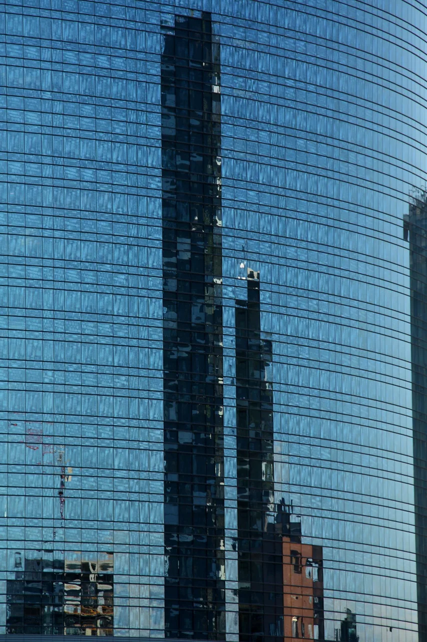 The two Bosco Verticale towers in Milan, with varied trees extending from balconies across both façades