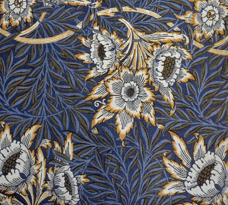 A William Morris textile repeating slender willow leaves and white tulip-like flowers across a deep indigo ground