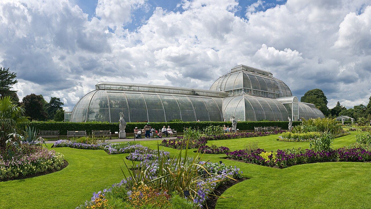 Kew Gardens Palm House seen across lawns and flower beds